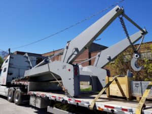 Photo of a JT Fabrication lugger truck body on a flat bed truck being shipped for installation on the other side of the country